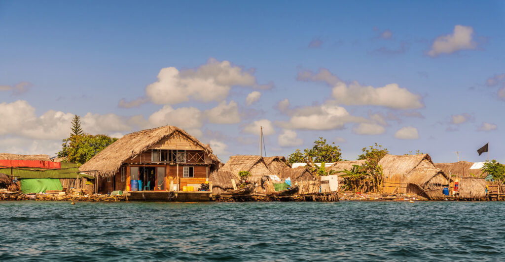 Maison au bord de la mer dans un État insulaire, menacée par la montée des eaux due au changement climatique.