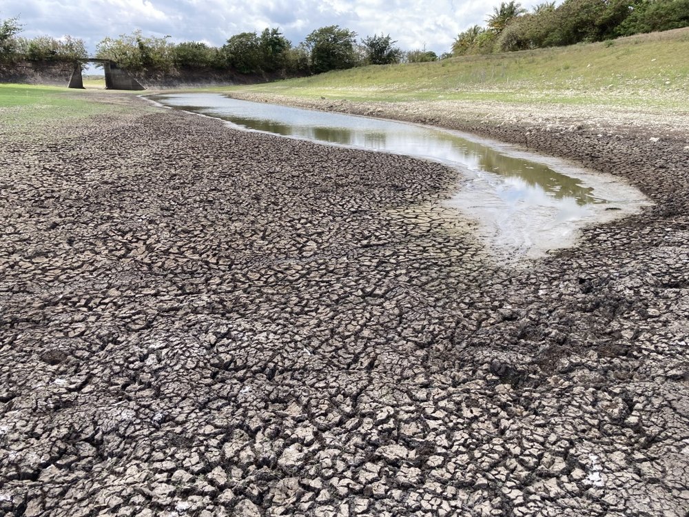 Paysage sec avec une rivière asséchée symbolisant la crise mondiale de l’eau douce.