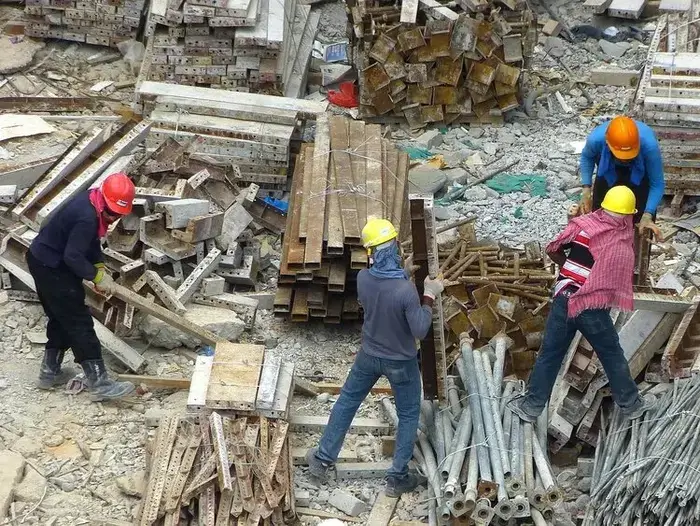 Ouvriers triant et séparant les matériaux de construction pour leur recyclage sur un chantier.
