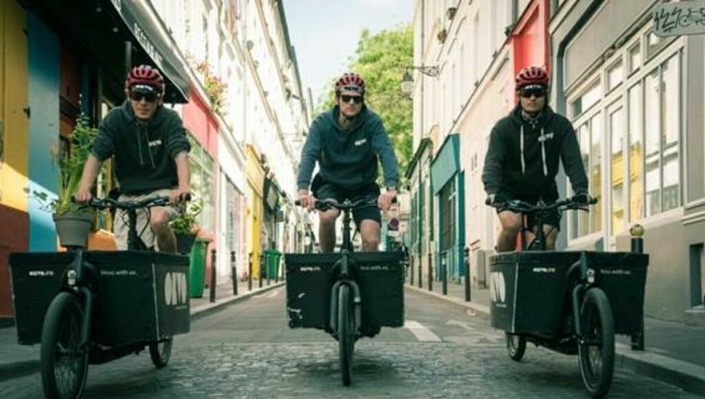 Livreurs en vélo-cargo dans une rue piétonne