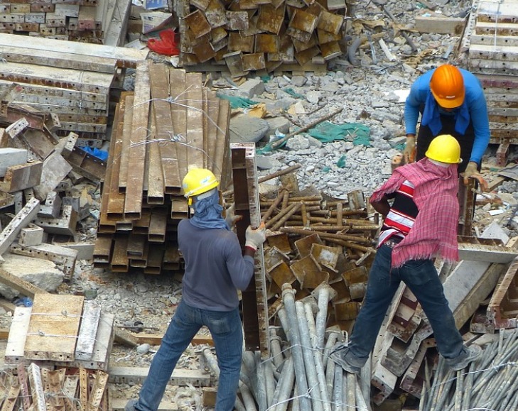 Ouvriers triant des matériaux de construction sur un chantier de recyclage.